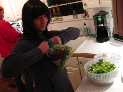 a girl putting vegetables into a bowl