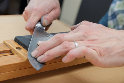 a pair of hands carefully polishing a kitchen tool