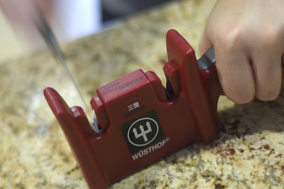 a red device polishing a kitchen tool