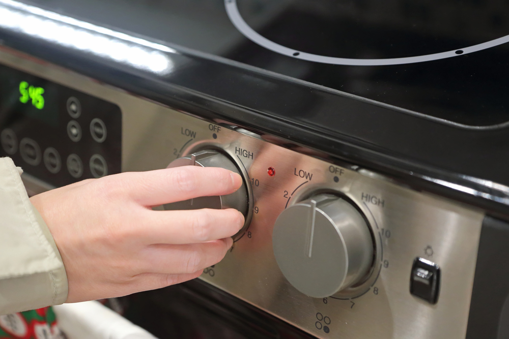 A woman adjusting settings of a kitchen appliance